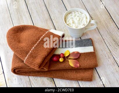 Toque et écharpe d'hiver chauds et délicieux chocolat chaud avec une crème à fouetter à déguster et à déguster en automne jours après les promenades dans les feuilles d'automne Banque D'Images