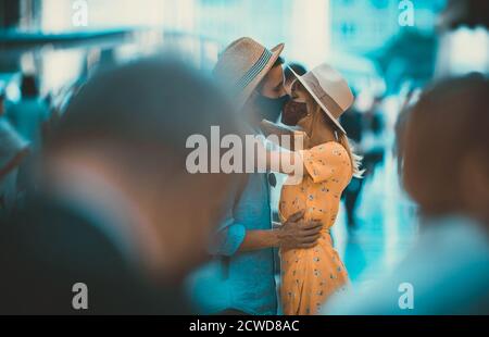 Image d'un couple heureux en vacances. Un jeune homme et une jeune femme qui embrassent la foule Banque D'Images