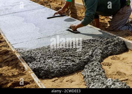 Poser un nouveau trottoir dans du béton humide sur du béton fraîchement coulé trottoirs en béton Banque D'Images