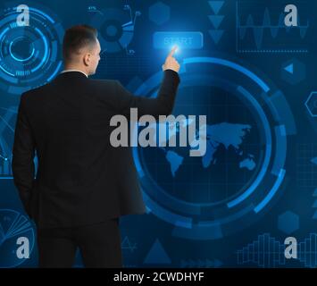 Homme d'affaires méconnu en appuyant sur le bouton Démarrer du panneau virtuel, fond bleu Banque D'Images