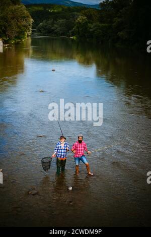 Portrait de deux hommes barbus joyeux qui pêchent. Volent poisson passe-temps des hommes dans une chemise à carreaux. Détendez-vous dans la nature. Hommes barbus pêcheurs. Commencez à vivre. C'est tout simplement le cas Banque D'Images