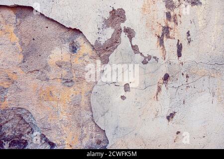 Ancienne texture d'arrière-plan de mur peint abîmé. Mur en plâtre léger et pelé avec des flocons de peinture qui tombent Banque D'Images