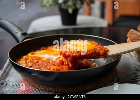 Shakshouka - oeufs dans une sauce tomate, servis dans une poêle Banque D'Images