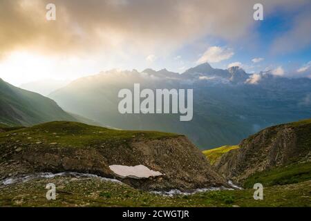 Brume sur les pics rocheux et les prairies entourant le col de Furka, canton d'Uri, Suisse Banque D'Images