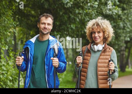 Portrait de jeunes heureux couple souriant à l'appareil photo pendant leur randonnée dans la forêt en été Banque D'Images