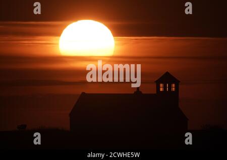 Le soleil se lève derrière le Watch House Museum à Seaton Sluice dans le Northumberland. Banque D'Images