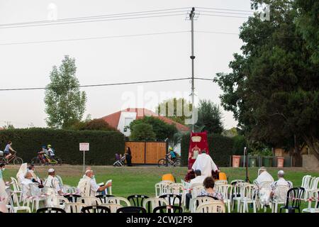 En raison de la COVID-19, prières sur le jour juif des Expiations, (Yom Kippur). Ont été maintenus en plein air tout en essayant de maintenir la distance personnelle amd porter des masques chirurgicaux. Tandis que les Israéliens laïques peuvent être vus à vélo et jouer dans le parc. L'épidémie de COVID-19 a forcé les gouvernements du monde entier à imposer une quarantaine civile. Le résultat est un contact limité entre les gens et une interaction sociale minimale. Photographié à Kfar Yona Israel le 28 2020 septembre Banque D'Images