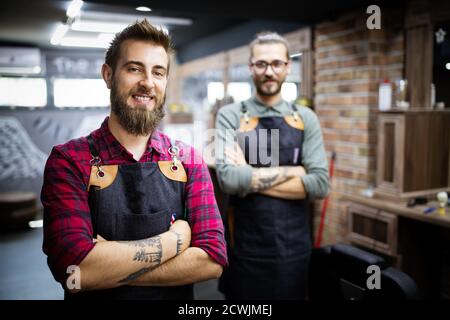 Portrait de jeunes hommes barbers et coiffeurs dans le salon de coiffure Banque D'Images