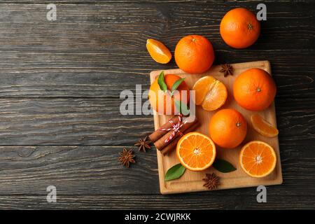 Planche avec mandarines et cannelle sur fond de bois Banque D'Images