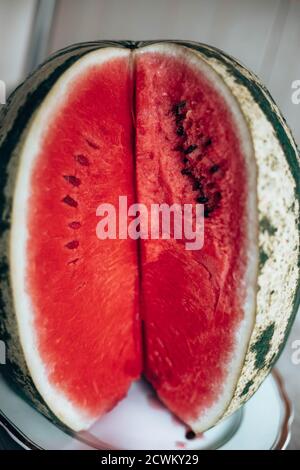 Trancher la pastèque sur une assiette blanche. Orientation verticale de la photo. Livre de fond sur les aliments. Banque D'Images