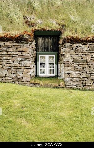 Toit en gazon islandais traditionnel et maison en pierre avec fenêtre en Islande. Banque D'Images