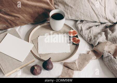 Petit déjeuner d'automne encore la vie. Fruits à la figue, livre et tasse de café sur plaque en céramique. Cartes de vœux vierges, fond en lin. Velours et lin Banque D'Images