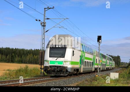 Train de voyageurs électrique Intercity de 2 étages du groupe VR moderne en déplacement au passage à niveau du chemin de fer rural. Humppila, Finlande. 18 septembre 2020. Banque D'Images