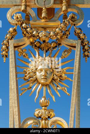 Symbole de Louis XIV le Roi Soleil sur l'or Porte du château de Versailles Banque D'Images