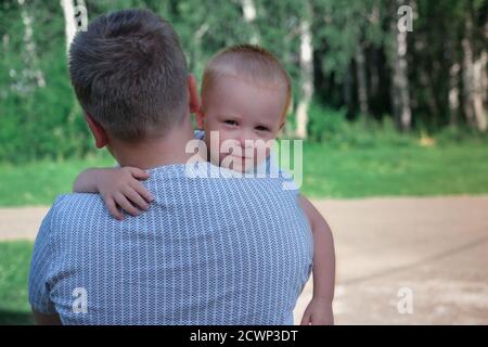 petit frère assis sur les mains du frère aîné. petit garçon blond embrassant son frère. togetherness et concept de soutien familial. Banque D'Images