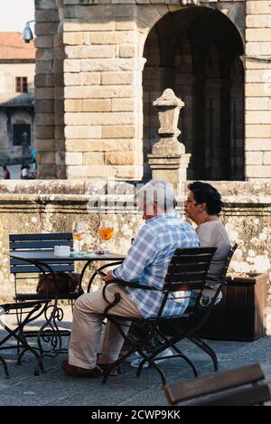 Saint-Jacques-de-Compostelle, Espagne - 18 juillet 2020 : couple d'âge moyen non identifié qui apprécie un verre de vin dans un café de la place Obradoiro Banque D'Images