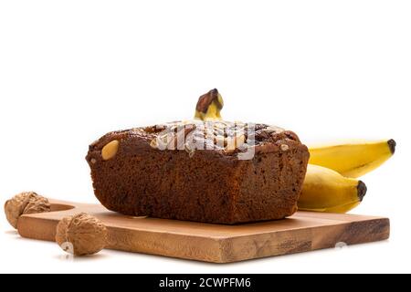 Pain à la banane sur plaque en bois avec banane isolée sur fond blanc. Banque D'Images