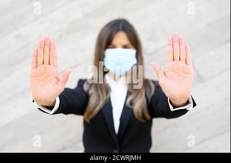 Concept de coronavirus. Femme portant un masque pour la protection contre la maladie, montre stop geste avec les mains, pour arrêter l'épidémie de coronavirus. Appel international pour rester à la maison. Photo de haute qualité. Banque D'Images