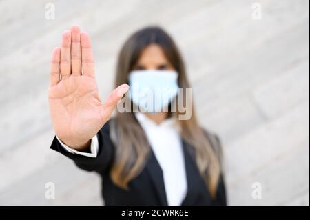 Concept de coronavirus. Femme portant un masque pour la protection contre la maladie, montre stop geste avec les mains, pour arrêter l'épidémie de coronavirus. Appel international pour rester à la maison. Photo de haute qualité. Banque D'Images