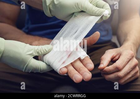 premiers soins - médecin traumatologue bandage patient blessé main Banque D'Images