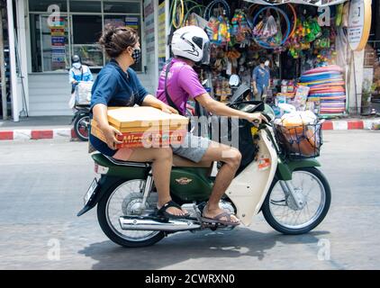 SAMUT PRAKAN, THAÏLANDE, APR 18 2020, la paire roule en moto avec un paquet de beignets Banque D'Images