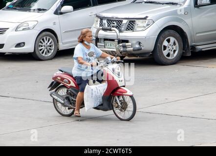 SAMUT PRAKAN, THAÏLANDE, JUL 03 2020, une femme roule sur une moto avec une charge de sac lourd. Banque D'Images