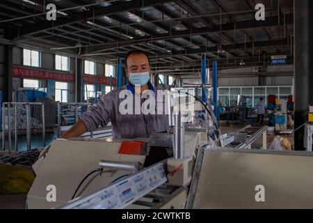 (200930) -- URUMQI, 30 septembre 2020 (Xinhua) -- UN travailleur fabrique des cadres de portes et de fenêtres dans une usine du comté de Pishan, préfecture de Hotan, dans la région autonome de Xinjiang, dans le nord-ouest de la Chine, le 23 septembre 2020. La région autonome de Xinjiang Uygur, dans le nord-ouest de la Chine, a créé quelque 2 millions de nouveaux emplois pour ses résidents de 2014 à 19. Depuis le 18e Congrès national du Parti communiste de Chine (PCC) en 2012, Xinjiang a mis en œuvre vigoureusement des projets d'emploi et amélioré la formation professionnelle, et a élargi les canaux et les capacités de l'emploi. De 2014 à 19, le nombre total de personnes e Banque D'Images