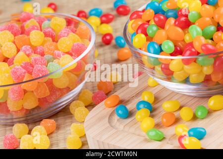 De délicieux grains de gelée et des gouttes de gomme de fruits dans des bols en verre sur fond en bois Banque D'Images