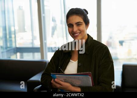 Portrait confident businesswoman with paperwork in office Banque D'Images