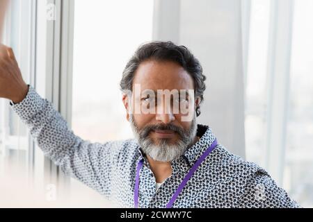 Portrait confiant homme d'affaires à la fenêtre Banque D'Images