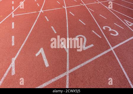 Lignes et chiffres peints en blanc sur une piste de course dans un terrain d'athlétisme et de sport. . Photo de haute qualité Banque D'Images