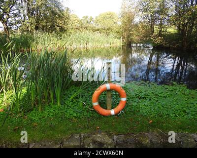 Un anneau de sauvetage (ceinture de sécurité) s'est installé près d'un étang de campagne profond dans le Lancashire, au Royaume-Uni, placé dans un endroit de haute visibilité Banque D'Images