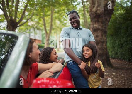 Bonne famille riant au convertible dans l'allée Banque D'Images