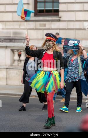 Une femme portant un masque de visage rejoint Pantomime dames lorsqu'elle marche à travers Londres. Pantomime dames a traversé Londres, tandis qu'ils se joignent à d'autres créatifs pour souligner la situation critique de l'industrie du théâtre et de ses travailleurs provoquée par la pandémie COVID-19. Banque D'Images