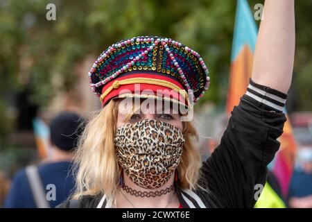 Une femme portant un masque de visage rejoint Pantomime dames lorsqu'elle marche à travers Londres. Pantomime dames a traversé Londres, tandis qu'ils se joignent à d'autres créatifs pour souligner la situation critique de l'industrie du théâtre et de ses travailleurs provoquée par la pandémie COVID-19. Banque D'Images