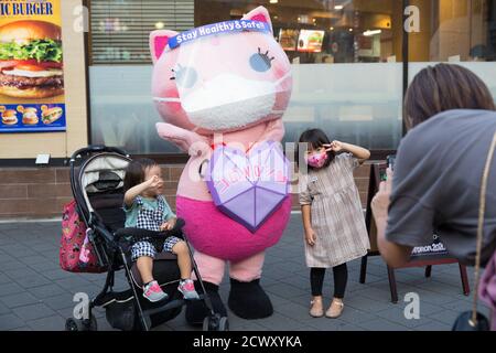 Koronon, une mascotte japonaise anti-coronavirus pour chats pose avec des enfants pour une photo à Ikebukuro, Tokyo.Koronon, une mascotte japonaise anti-coronavirus pour chats qui met en mains des masques jetables et sensibilise les piétons aux vagues du coronavirus (Covid-19) à Ikebukuro, Tokyo. Koronon peut également être réservé pour visiter des écoles et des entreprises pour partager son message sur l'hygiène et d'autres mesures de lutte contre Covid-19. Banque D'Images