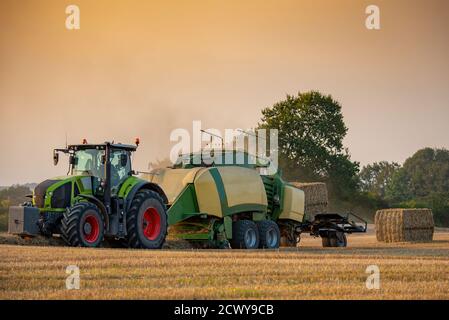 Un tracteur qui effectue son travail saisonnier dans un champ de blé, Jutland, Danemark. Banque D'Images