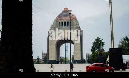 Monument à la Révolution de l'autre côté de la rue avec un rouge Voiture qui passe Banque D'Images