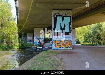 Un bateau étroit qui passe sous l'autoroute M25 Le canal de navigation de la rivière Wey à New Haw Surrey, en Angleterre ROYAUME-UNI Banque D'Images