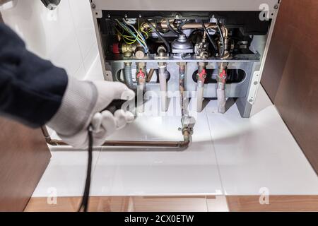 Technicien inspectant un chauffe-gaz ou une chaudière de chauffage dans une maison. Concept de maintenance Banque D'Images