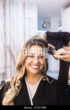 Femme cheveux curling coiffeur en salon de coiffure client Banque D'Images