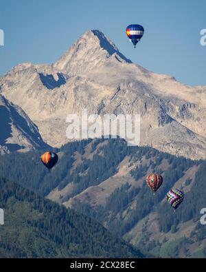 Ballons d'air chaud volant contre la montagne Banque D'Images