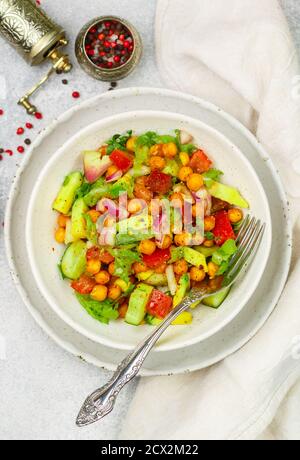 Salade végétarienne ou végétalienne saine et délicieuse avec pois chiches, laitue, avocat, concombre, tomates, oignon rouge, huile d'olive et épices. Sélectif Banque D'Images