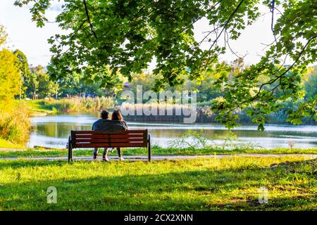 Couple assis sur un banc dans le parc Szczesliwicki (parc Szczęśliwicki), district d'Ochota, Varsovie, Pologne Banque D'Images