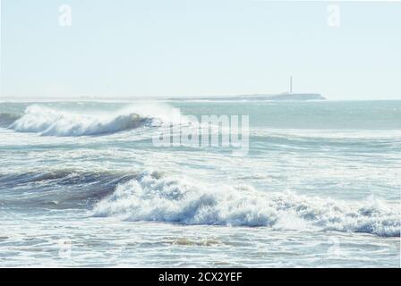 Vagues s'écrasant devant un phare au Sahara occidental, au Maroc, en Afrique du Nord Banque D'Images