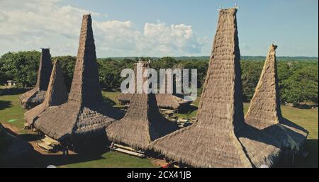 Vue aérienne de près du village traditionnel avec toitures ornately toitures cottages. Forêt tropicale à long-tenu village traditionnel de campagne. Indonésie paysage de l'île de Sumba attraction en tir de drone Banque D'Images