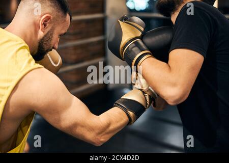 Boxeur masculin attaquant l'adversaire avec un crochet droit Banque D'Images