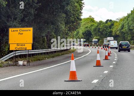 WORCESTERSHIRE, ANGLETERRE - SEPTEMBRE 2018 : des cônes de circulation sur l'autoroute M50 ferment une voie pour couper l'herbe Banque D'Images