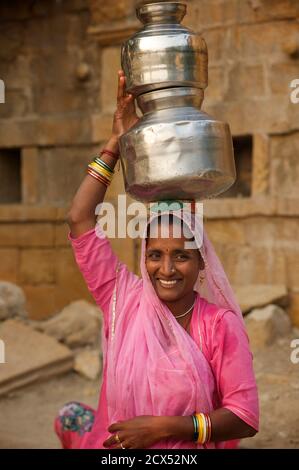 Femme du Rajasthan la collecte de l'eau d'un puits à Amar Sagar, Lodurva nr, Jaisalmer, Rajasthan, India Banque D'Images