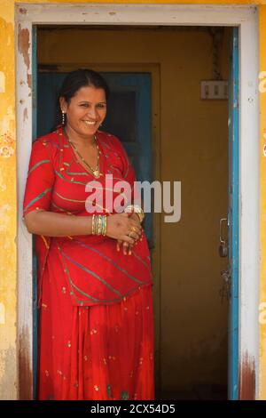 Portrait d'une femme indienne à l'extérieur de sa maison, Mandawa, région de Shekawati, Inde du Rajasthan. Cette image contient des éléments culturellement pertinents: Shalwar kameez, également orthographié salwar kameez ou shalwar qameez, est une tenue traditionnelle originaire d'Asie du Sud et du Centre et est un terme générique utilisé pour décrire différents styles de robe. Le shalwar kameez peut être porté à la fois par les hommes et les femmes, bien que les styles diffèrent selon le sexe. Le shalwar et le kameez sont deux vêtements qui ont été combinés pour former la tenue du shalwar kameez. Banque D'Images